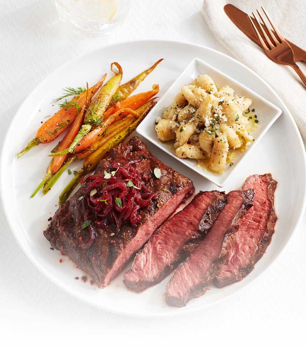 Grilled flat iron steak with red onion marmalade, crispy herbed gnocci and baby carrots