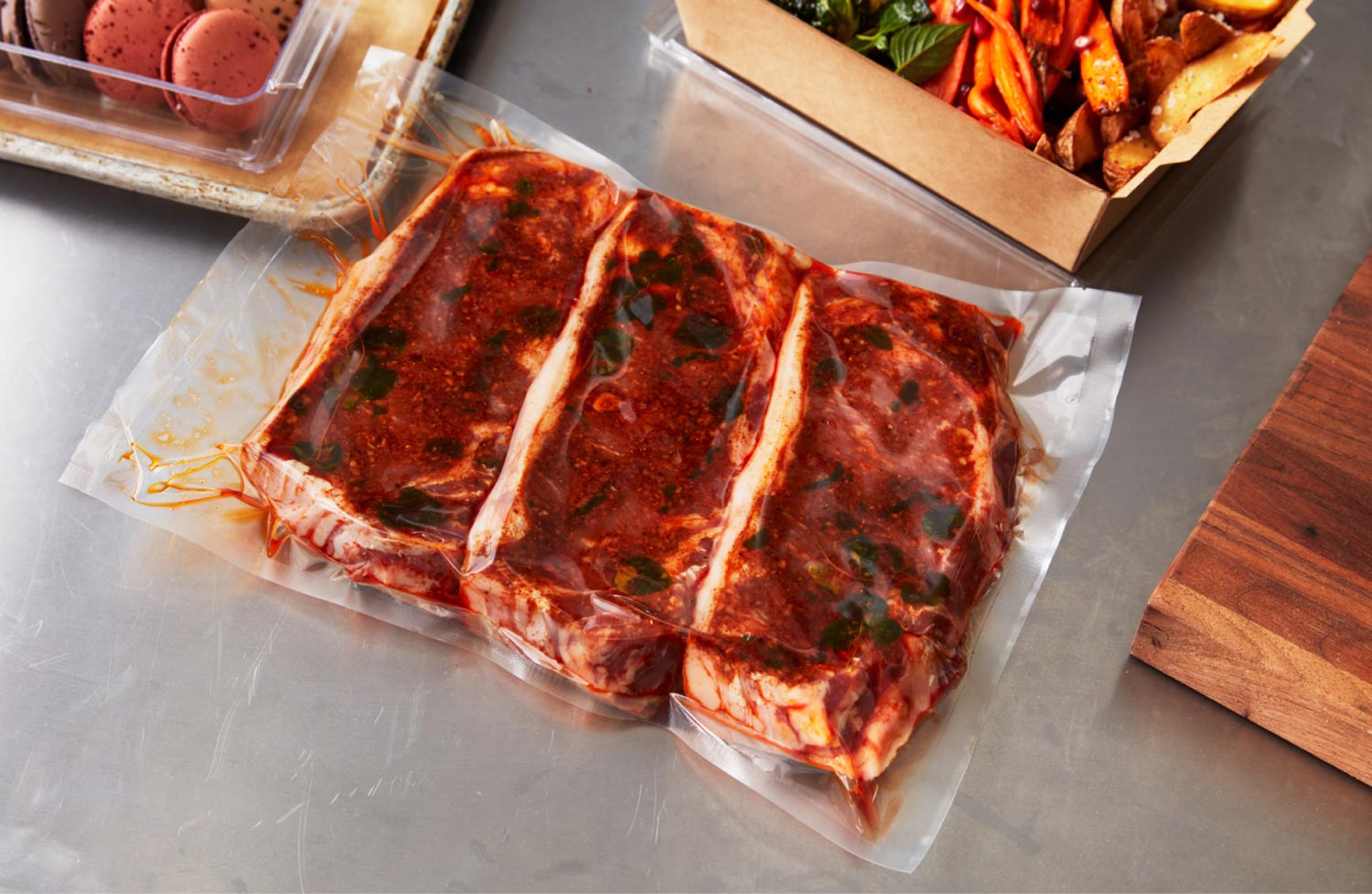 Vacuum-sealed 3-pack of New York strip steaks in a house-made marinade on the counter of a restaurant retail market