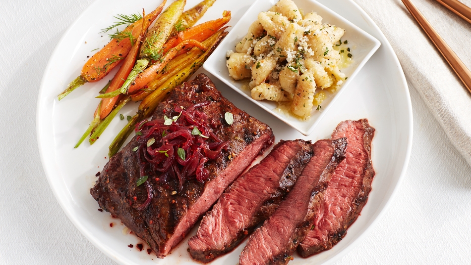 Grilled flat iron steak with red onion marmalade, crispy herbed gnocchi and baby carrots